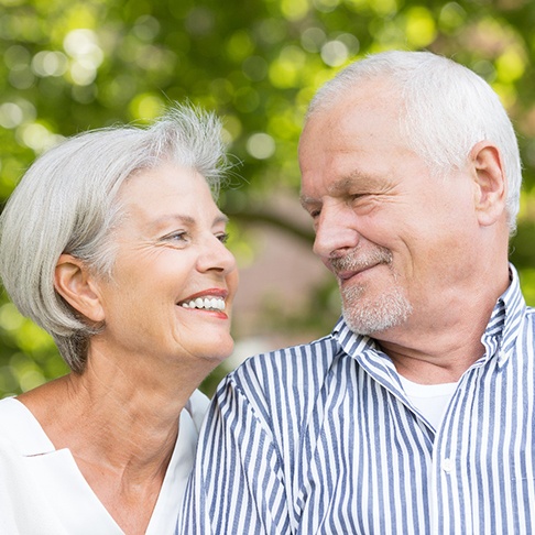 older couple smiling while looking at each other 