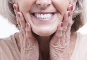 a patient smiling after receiving dental implants 